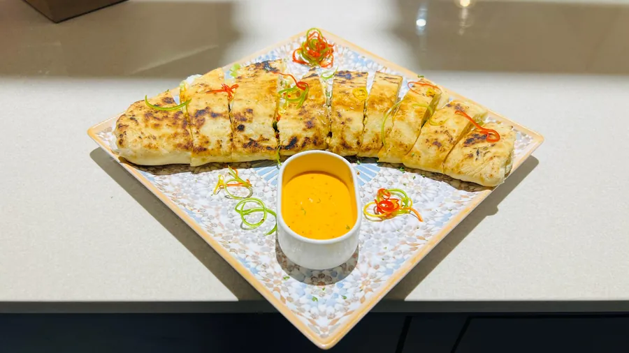 Grilled pizza sandwiches sliced to share, with a warm dip