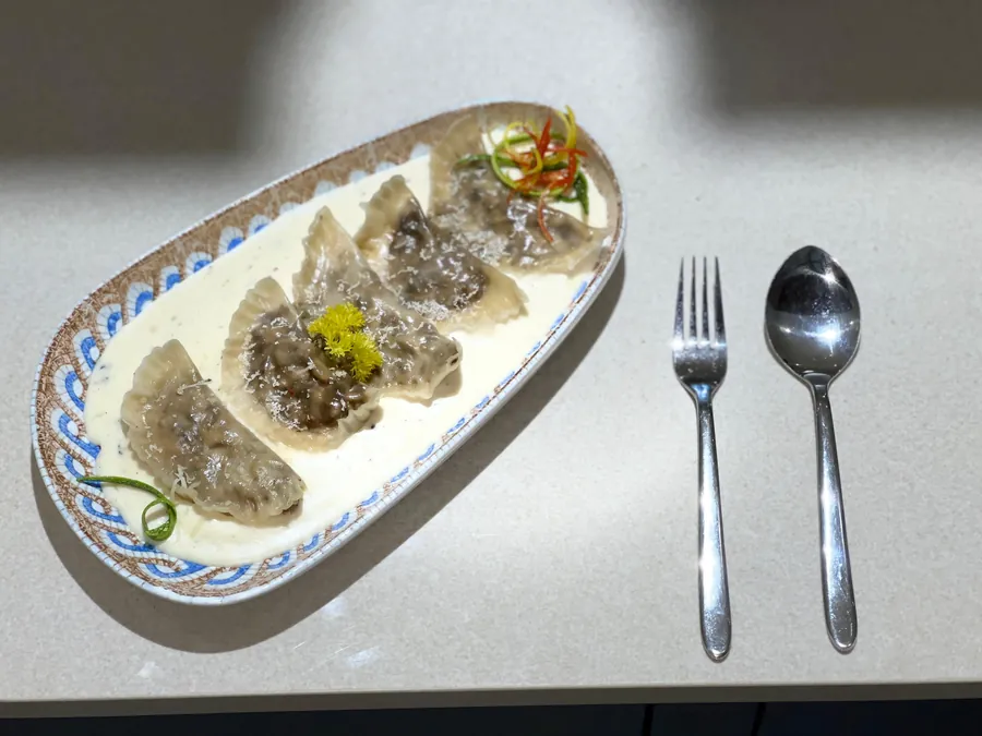 Mushroom truffle ravioli on an oval platter over cream
